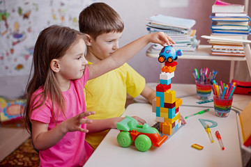 Children doing homework and plays with his favorite toys at home . Learning at home, self quarantine concept. Epidemic of coronavirus. Self-isolation, home quarantine. Distance learning at home.