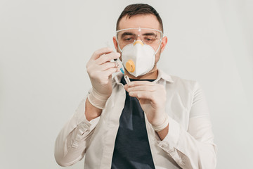 brunette man medical doctor scientist in glasses and protective mask with syringe vaccine in hands in hospital, laboratory. Medication for coronavirus illness, infection, quarantine, surgical bandage