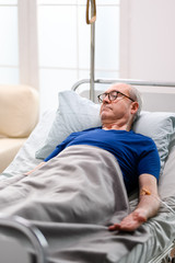 Retired old man in nursing home laying on bed