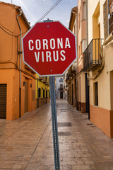 Red sign CORONA VIRUS in the middle of empty european old town street - virus outbreak lockdown