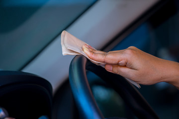 Asian women spry soap and clean car steering wheel with napkin, concept for  Coronavirus, Covit-19 prevention and disinfection.