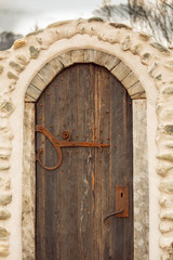 Old wooden weathered castle door with wrought iron