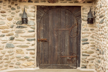 Old wooden weathered castle door with wrought iron