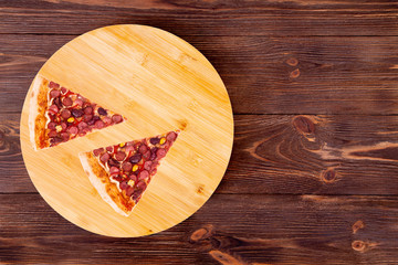 Two slices of pizza Mexico, on bamboo bottom, on wooden table, top view, space for text