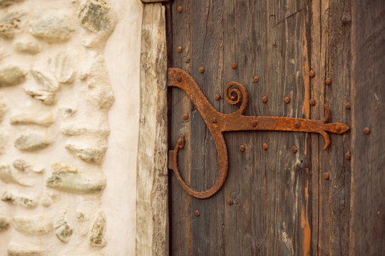 Old wooden weathered castle door with wrought iron