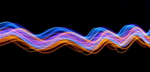 Light painting photography, long exposure photo of blue and gold loops and swirls of vibrant color,...
