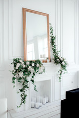 Composition of ivy and roses on a white wall near the mirror in golden frame background