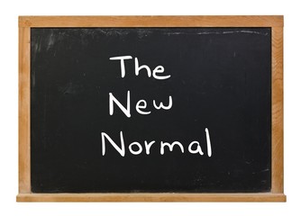 The new normal written in white chalk on a black chalkboard isolated on white