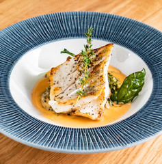 Fried fish fillet. Cod with sauce and herbs