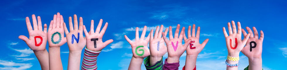 Children Hands Building Colorful English Word Do Not Give Up. Blue Sky As Background