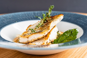 Fried fish fillet. Cod with sauce and herbs