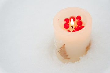 Obraz na płótnie Canvas a burning candle on white pure snow