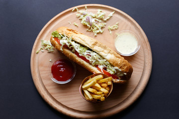 Hot Dogs with French fries and ketchup on wooden plate. Top view.