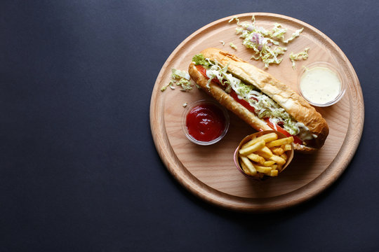 Hot Dogs with French fries and ketchup on wooden plate. Top view.