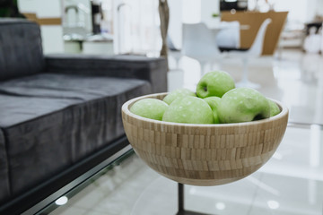 Green juicy apples. Ripe apples in a wooden plate. 