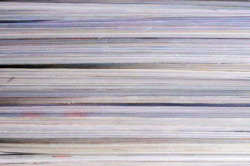Closeup background of a pile of magazines.
