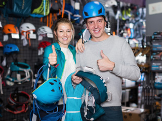 Fototapeta na wymiar Young couple in sports shop choosing sports equipment