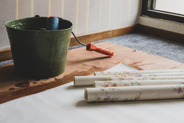 Several Roll of Wallpaper and a bucket of glue for installation process