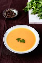 Healthy Vegetable Cream Soup in a bowl on linen tablecloth. Vertical composition. Selective focus