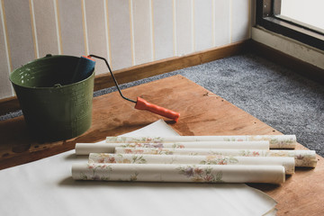 Several Roll of Wallpaper and a bucket of glue for installation process