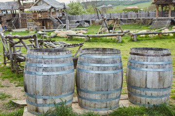 Ancient wooden barrels surrounded by a reconstructed medieval village.