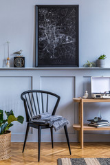 Stylish scandinavian living room interior with design black chair, wooden console, plants, books, decoration, mock up poster map on the shelf and elegant accessories in modern home decor.