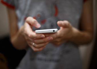 Cropped image of woman's hands holding cell telephone .