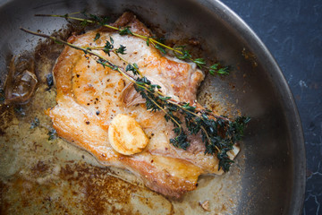 Cooking, Pork Steak with Thyme in a Metal Pan, Close up on dark background