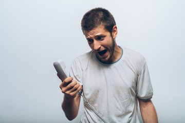 Close up image of a man screaming on the telephone during the conversation.