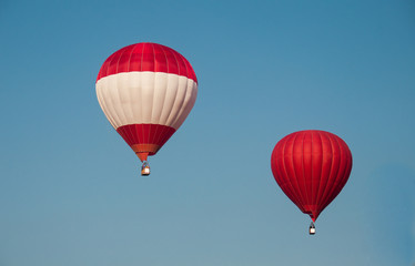 Colorful hot-air balloons fly in the blue sky. red balloon. red and white balloons. Space for text.