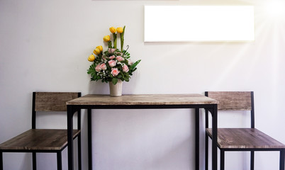 Still life with a bouquet of garden flowers in a glass jug on the table against the cement wall background