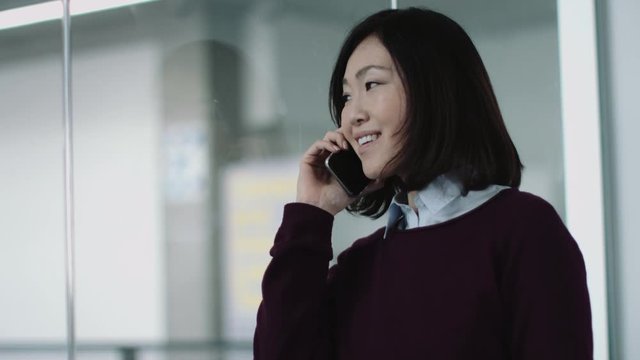 Japanese business woman in office talking on phone