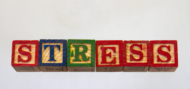 The term stress isolated on a clear background using colored wooden toy blocks image in horizontal format with copy space