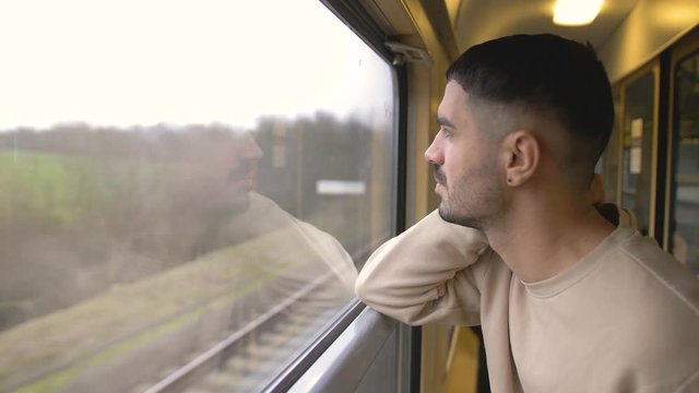 young boy traveling by train looks out the window
