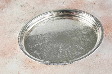 Antique silver plated tray on concrete background.