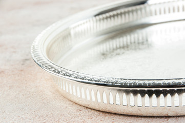 Antique silver plated tray on concrete background.