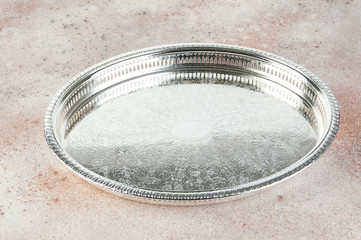 Antique silver plated tray on concrete background.