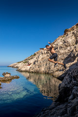 Guy jumping into the water at Korakonissi in summer