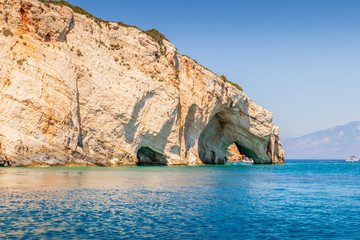 Boats passing through an arched cliff near the Blue Caves on Zakynthos