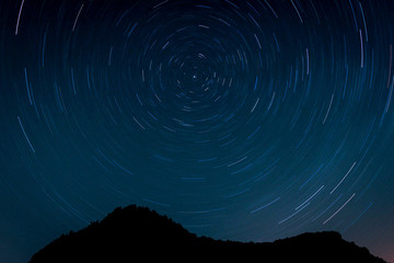 Starry sky with some mountains. Circumpolar star trail