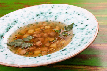 Buckwheat soup with porcini mushrooms. On a colored wooden background. Vegetarian dish.