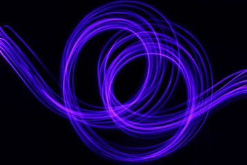 Long exposure photograph of neon blue streaks of light in an abstract swirl, parallel lines pattern...