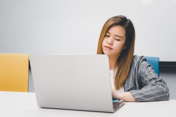 Woman working by laptop in office with happy