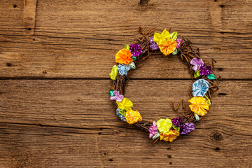 Spring composition of a wreath of birch branches and craft colorful flowers