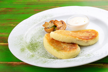 Potato zrazy with sour cream. On a colored wooden background. Vegetarian dish.