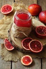 Still life with red oranges and lemons on a wooden background