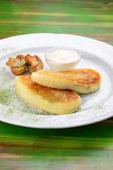 Potato zrazy with sour cream. On a colored wooden background. Vegetarian dish.