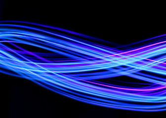 Long exposure photograph of neon blue streaks of light in an abstract swirl, parallel lines pattern...