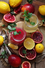 Still life with red oranges and lemons on a wooden background
