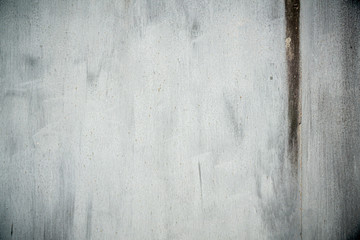 Textured old grunge gray metal background covered in peeling paint with light dark vignette in the corners.